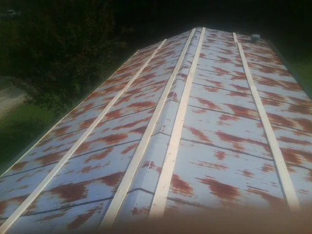 Rusted metal roof panels with new wood purlins before replacement — Storm Damage Roof Repair in Nobleton by Roofing Brothers