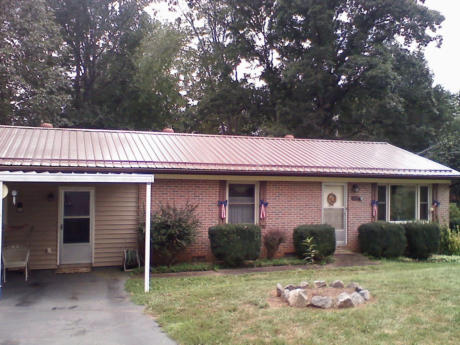 Bronze metal roof and carport on a brick ranch home — Roof Repair work by our crew in Nobleton